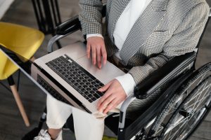 Image by SHVETS productions. Crop image of wheelchair user typing on laptop